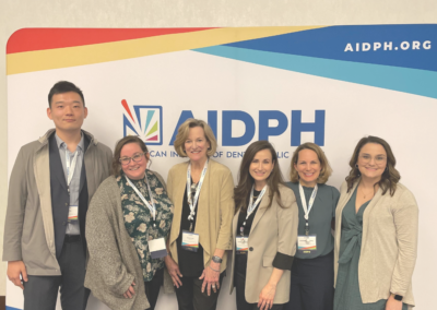 AIDPH team gathered at Colloquium by official backdrop