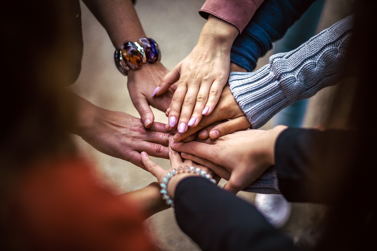 A diverse group of people joining hands together